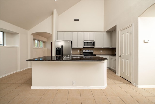2401 Fawn Meadow Dr, Little Elm, TX 75068 - kitchen with appliances with stainless steel finishes, high vaulted ceiling, arched walkways, light tile patterned flooring, and backsplash