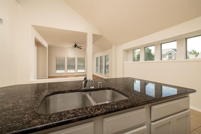 2401 Fawn Meadow Dr, Little Elm, TX 75068 - kitchen with dark stone counters, ceiling fan, lofted ceiling, and white cabinetry