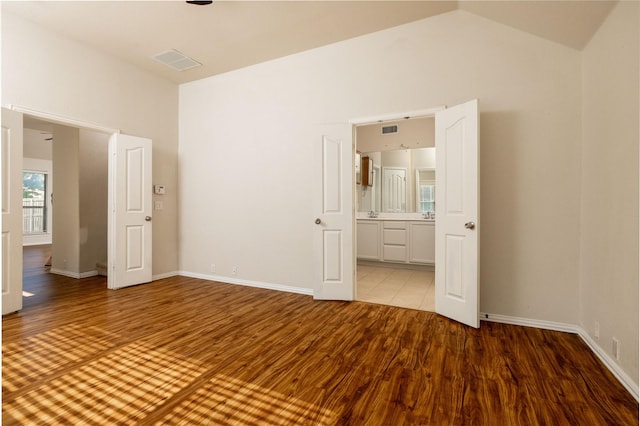 2401 Fawn Meadow Dr, Little Elm, TX 75068 - unfurnished bedroom featuring wood finished floors, vaulted ceiling, and ensuite bathroom