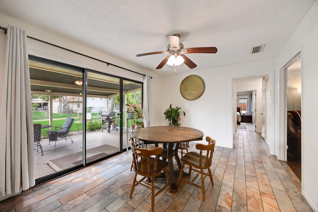 13835 Pyramid Dr, Farmers Branch, TX 75234 - dining area featuring ceiling fan, light wood-style flooring, and a textured ceiling