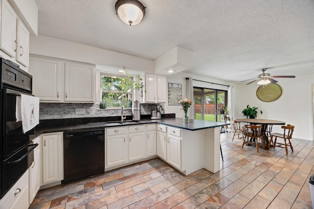 13835 Pyramid Dr, Farmers Branch, TX 75234 - kitchen featuring black appliances, a peninsula, a warming drawer, a textured ceiling, and dark countertops