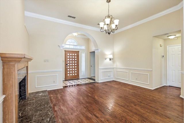 5219 Tennis Villa Dr, Arlington, TX 76017 - entryway featuring ornamental molding, a decorative wall, a chandelier, arched walkways, and a wainscoted wall