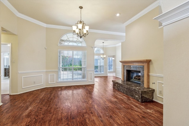 5219 Tennis Villa Dr, Arlington, TX 76017 - unfurnished living room with a chandelier, wood finished floors, crown molding, a fireplace, and a wainscoted wall