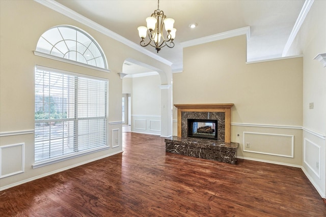 5219 Tennis Villa Dr, Arlington, TX 76017 - unfurnished living room featuring a chandelier, a decorative wall, a premium fireplace, wood finished floors, and crown molding