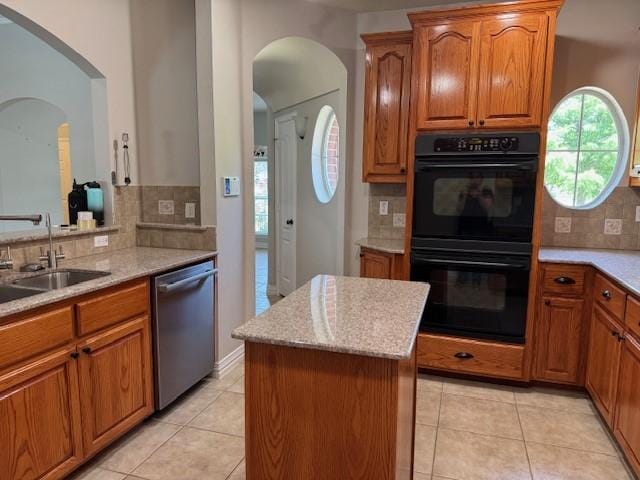 3840 W Pioneer Dr, Irving, TX 75061 - kitchen featuring dishwasher, tasteful backsplash, a kitchen island, brown cabinetry, and arched walkways