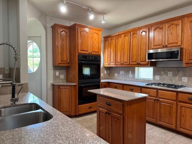 3840 W Pioneer Dr, Irving, TX 75061 - kitchen featuring stainless steel appliances, brown cabinets, and backsplash
