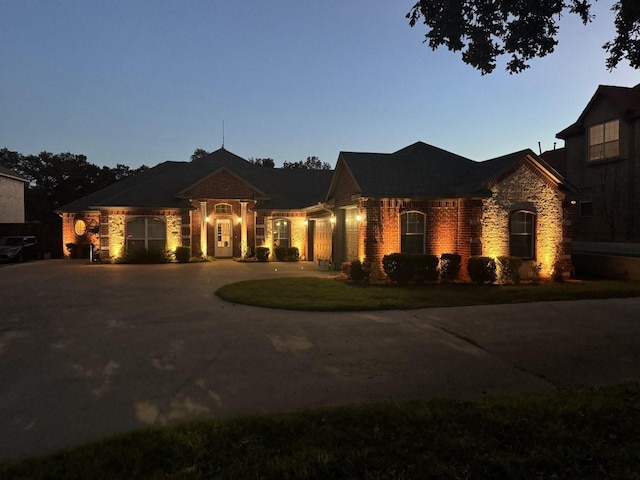 3840 W Pioneer Dr, Irving, TX 75061 - view of front of house with stone siding, curved driveway, and a front lawn