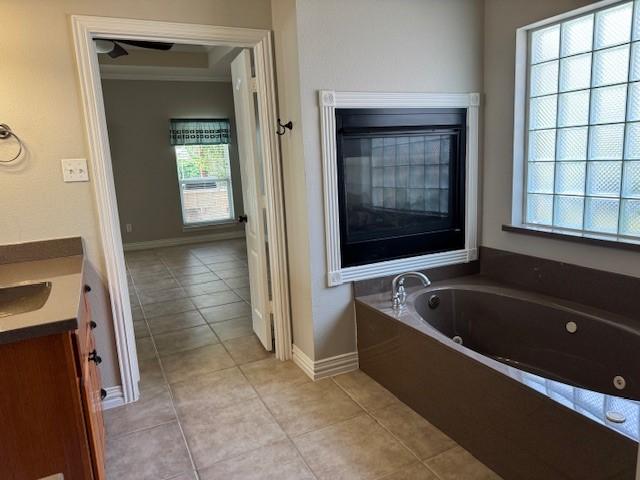 3840 W Pioneer Dr, Irving, TX 75061 - full bathroom featuring vanity, a tub with jets, tile patterned floors, and ornamental molding