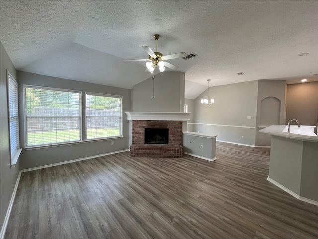 4400 Ripplewood Rd, Frisco, TX 75035 - unfurnished living room featuring ceiling fan, lofted ceiling, a textured ceiling, a fireplace, and dark wood-type flooring