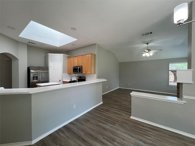 4400 Ripplewood Rd, Frisco, TX 75035 - kitchen featuring appliances with stainless steel finishes, a skylight, dark wood-style floors, light countertops, and a peninsula