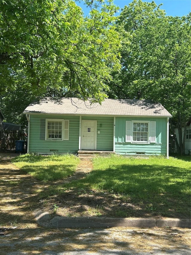 513 W Bullock St, Denison, TX 75020 - view of front facade with a front yard and board and batten siding