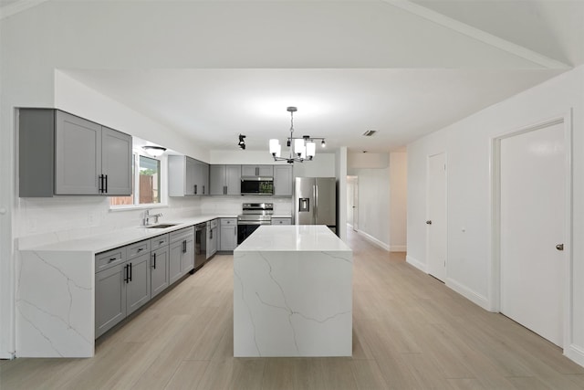2024 Oakmeadow St, Bedford, TX 76021 - kitchen with gray cabinets, appliances with stainless steel finishes, a chandelier, tasteful backsplash, and a kitchen island