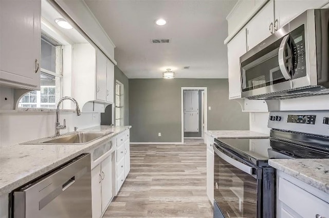 3501 NE 10th St, Mineral Wells, TX 76067 - kitchen with stainless steel appliances, white cabinetry, light wood-style floors, light stone counters, and recessed lighting