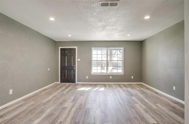 3501 NE 10th St, Mineral Wells, TX 76067 - empty room with light wood finished floors, a textured ceiling, and recessed lighting