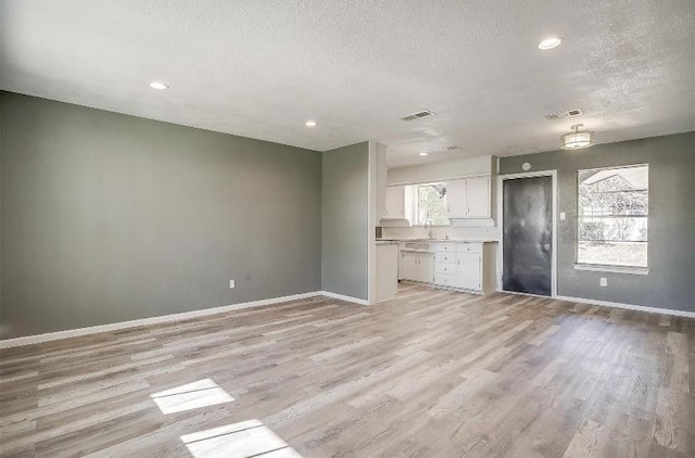 3501 NE 10th St, Mineral Wells, TX 76067 - unfurnished living room featuring a textured ceiling, light wood-style floors, and recessed lighting