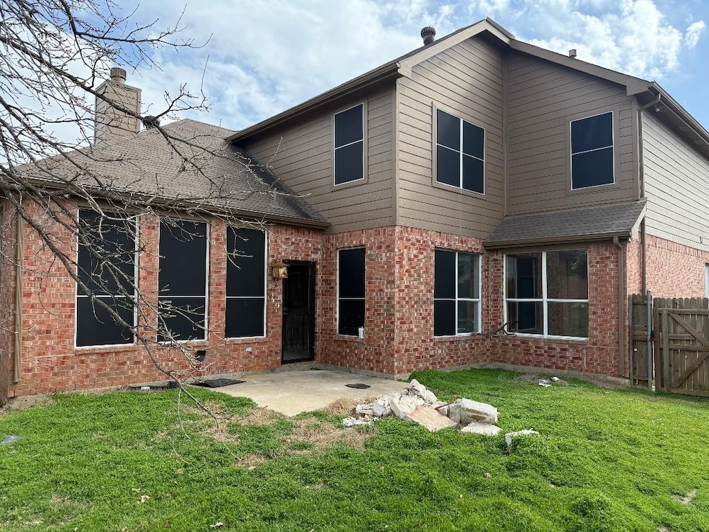 2011 Fair Oaks Cir, Corinth, TX 76210 - back of property with brick siding, a chimney, a patio area, and a gate