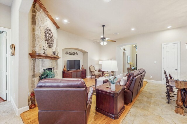 5768 Gallant Run, Frisco, TX 75033 - living room with arched walkways, a ceiling fan, a high end fireplace, and recessed lighting