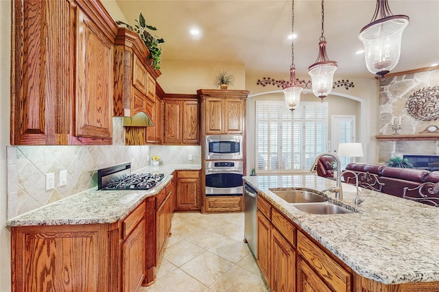 5768 Gallant Run, Frisco, TX 75033 - kitchen featuring stainless steel appliances, a fireplace, brown cabinets, decorative backsplash, and light stone counters