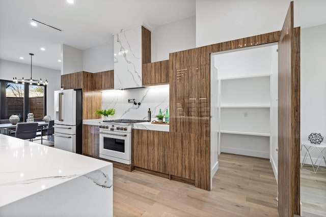 4603 Newmore Ave, Dallas, TX 75209 - kitchen featuring modern cabinets, high end appliances, brown cabinetry, light wood-style flooring, and tasteful backsplash