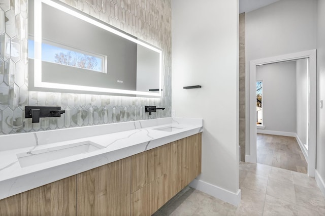 4603 Newmore Ave, Dallas, TX 75209 - bathroom featuring double vanity, tile patterned floors, and decorative backsplash