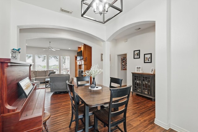 1128 Bent Oaks Dr, Denton, TX 76210 - dining room featuring arched walkways, dark wood-type flooring, a chandelier, and a ceiling fan