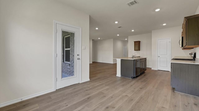 414 Drake Dr, Ferris, TX 75125 - kitchen with appliances with stainless steel finishes, an island with sink, light wood-style flooring, light countertops, and recessed lighting