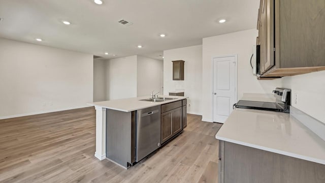 414 Drake Dr, Ferris, TX 75125 - kitchen featuring appliances with stainless steel finishes, light wood-style floors, recessed lighting, an island with sink, and light countertops