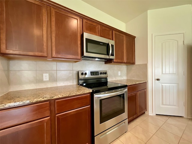 1092 Decker Dr, Fate, TX 75189 - kitchen featuring stainless steel appliances, light stone counters, light tile patterned flooring, and tasteful backsplash
