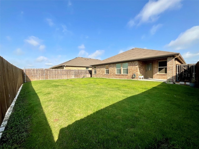 1092 Decker Dr, Fate, TX 75189 - back of property with brick siding, a fenced backyard, and a shingled roof