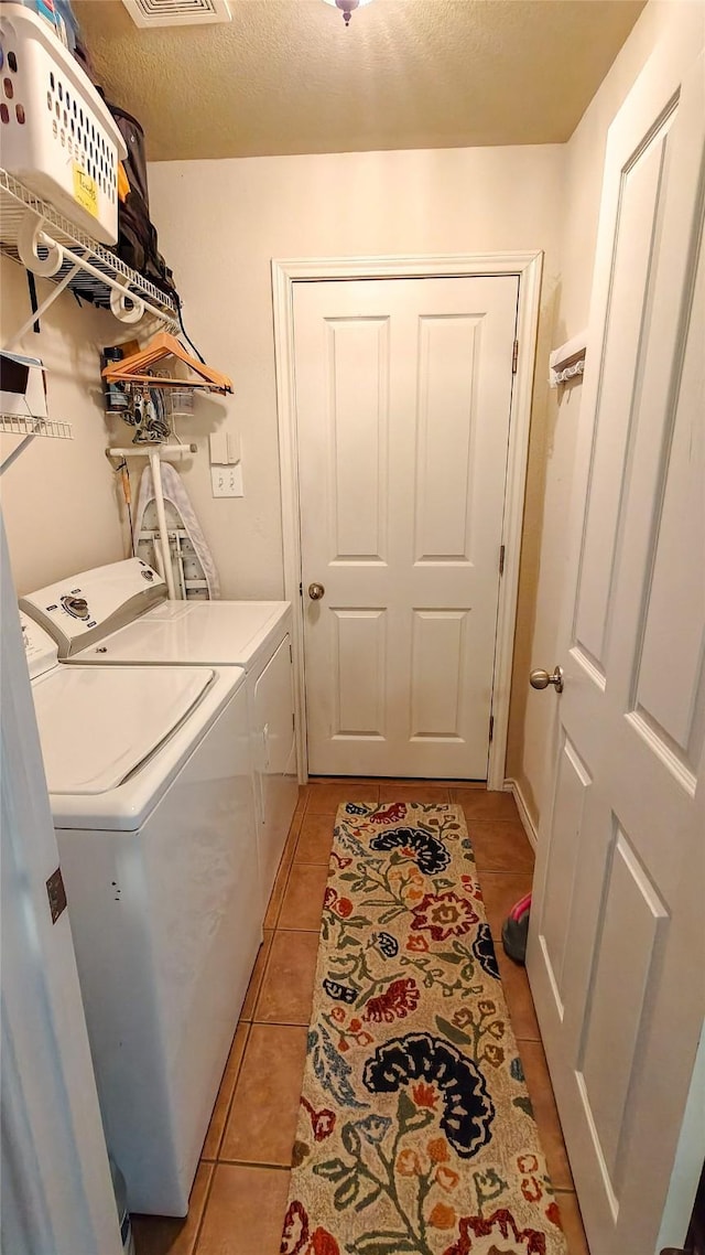 8901 Arbor Crest Ct, Fort Worth, TX 76179 - washroom with washer and dryer, light tile patterned floors, and a textured ceiling