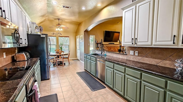 8901 Arbor Crest Ct, Fort Worth, TX 76179 - kitchen with green cabinets, appliances with stainless steel finishes, arched walkways, white cabinetry, and lofted ceiling