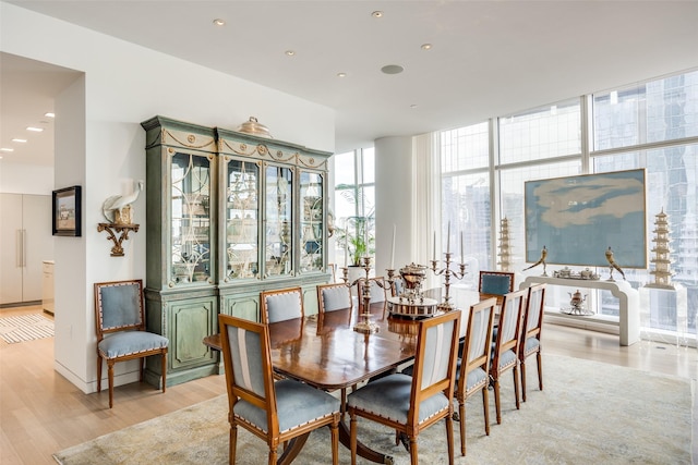 1918 Olive St Unit 502, Dallas, TX 75201 - dining room with light wood finished floors, a wall of windows, and recessed lighting
