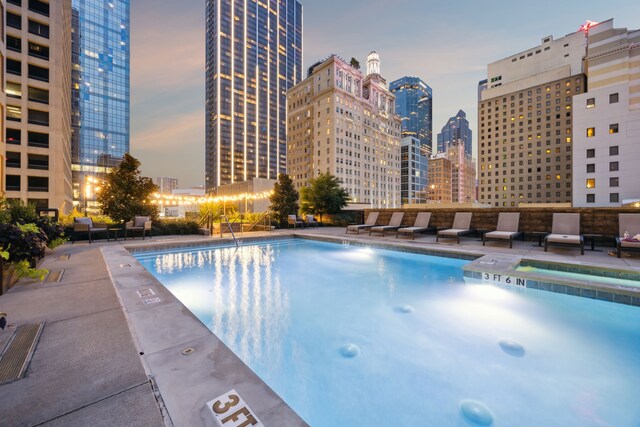 1200 Main St Unit 1106, Dallas, TX 75202 - pool at dusk featuring a city view, a community pool, and a patio area