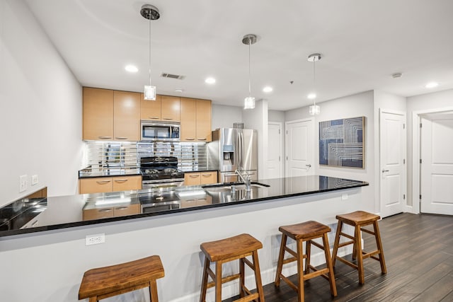 1200 Main St Unit 1106, Dallas, TX 75202 - kitchen with appliances with stainless steel finishes, dark wood-style floors, dark countertops, a kitchen bar, and backsplash