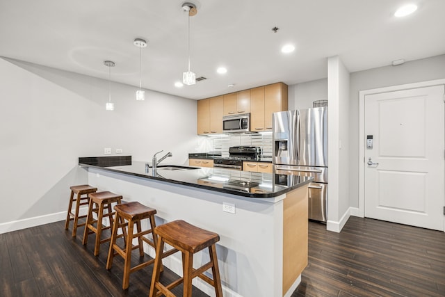 1200 Main St Unit 1106, Dallas, TX 75202 - kitchen with stainless steel appliances, dark countertops, a kitchen bar, a peninsula, and recessed lighting