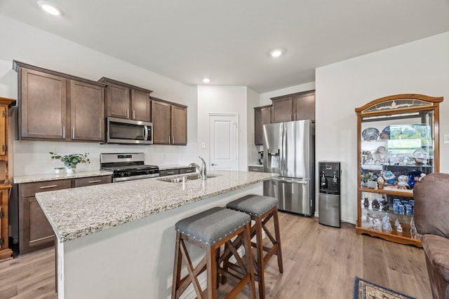 523 Summit Pass Ln, Princeton, TX 75407 - kitchen with stainless steel appliances, dark brown cabinetry, decorative backsplash, light wood finished floors, and recessed lighting