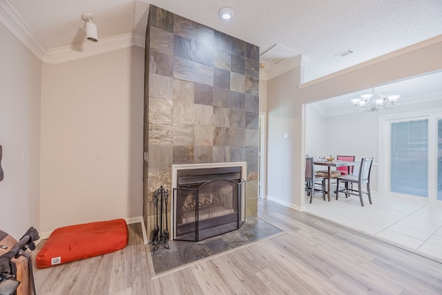 6508 Running Creek Dr, Arlington, TX 76001 - detailed view of crown molding, wood finished floors, a tiled fireplace, a chandelier, and a textured ceiling