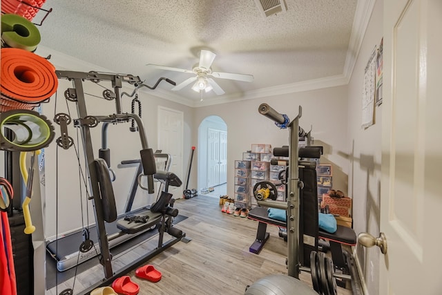 6508 Running Creek Dr, Arlington, TX 76001 - workout room featuring a textured ceiling, a ceiling fan, ornamental molding, arched walkways, and light wood finished floors