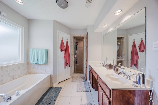 6508 Running Creek Dr, Arlington, TX 76001 - bathroom with a garden tub, double vanity, a shower stall, tile patterned flooring, and recessed lighting