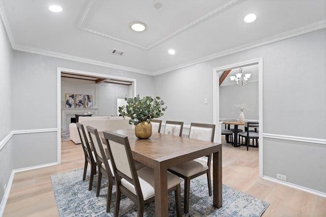 6104 Bluff Point Dr, Dallas, TX 75248 - dining area with light wood finished floors, recessed lighting, crown molding, a fireplace, and a chandelier