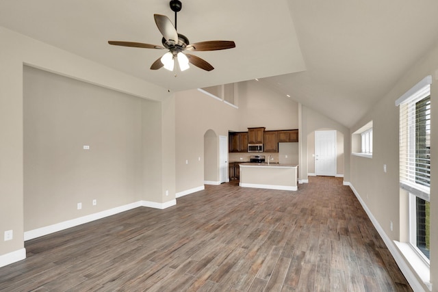 350 Windsor St, Waxahachie, TX 75165 - unfurnished living room featuring arched walkways, a ceiling fan, dark wood-style floors, and high vaulted ceiling