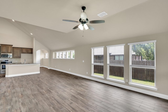 350 Windsor St, Waxahachie, TX 75165 - unfurnished living room featuring lofted ceiling, a ceiling fan, wood finished floors, and arched walkways