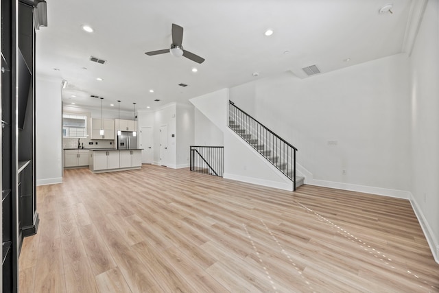 3200 Ross Ave Unit 22, Dallas, TX 75204 - unfurnished living room featuring a ceiling fan, recessed lighting, light wood-style flooring, and stairs