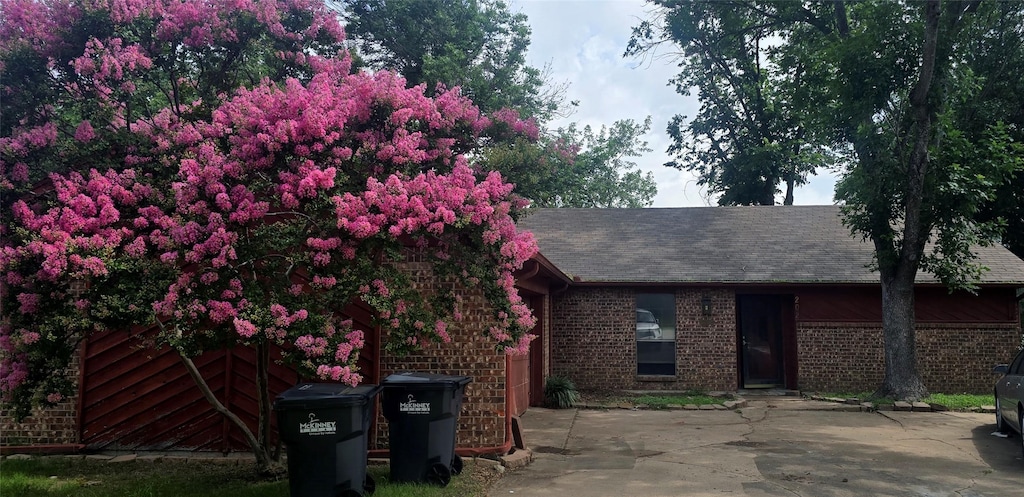 202 W Graham St, Mckinney, TX 75069 - view of front facade featuring a patio area, brick siding, and roof with shingles