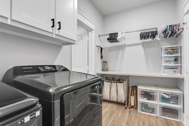 14423 Woodland Crk, Tyler, TX 75706 - laundry area with cabinet space, washing machine and clothes dryer, and light wood finished floors