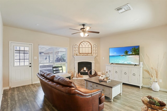 1117 Lake Woodland Dr, Little Elm, TX 75068 - living area with ceiling fan, wood finished floors, and a lit fireplace