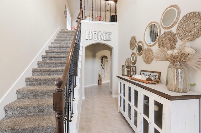 1117 Lake Woodland Dr, Little Elm, TX 75068 - staircase featuring arched walkways and tile patterned flooring