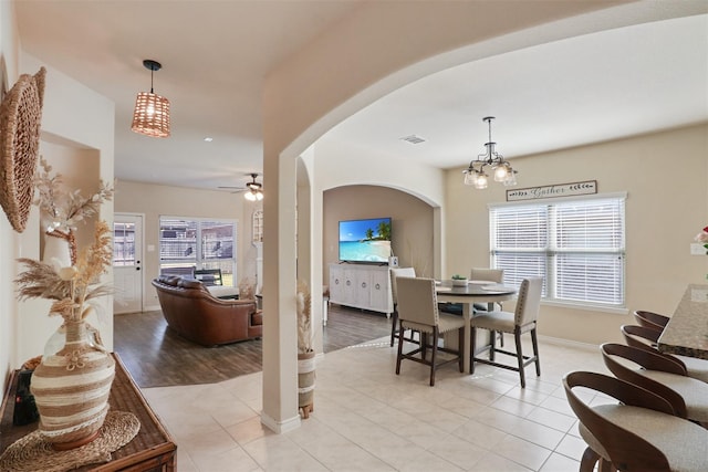1117 Lake Woodland Dr, Little Elm, TX 75068 - dining space with arched walkways, ceiling fan, light tile patterned floors, and a chandelier