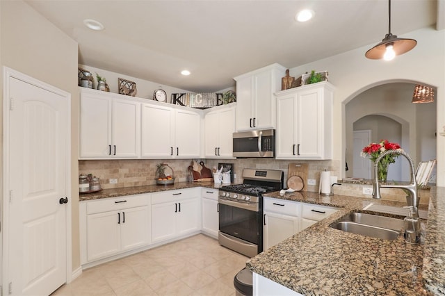 1117 Lake Woodland Dr, Little Elm, TX 75068 - kitchen with appliances with stainless steel finishes, tasteful backsplash, white cabinets, hanging light fixtures, and dark stone counters