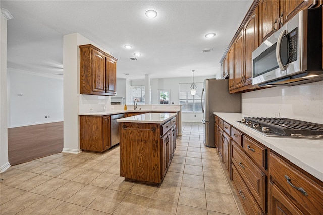 3403 Brighton Ct, Highland Village, TX 75077 - kitchen with stainless steel appliances, light countertops, a peninsula, a kitchen island, and recessed lighting